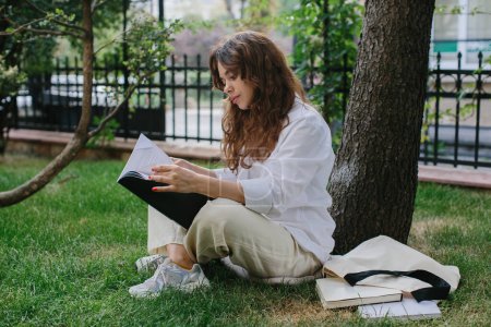 Photo for Magazine or book image mockup. The girl relaxes on the lawn in the courtyard of the coffee shop, reads a book. - Royalty Free Image
