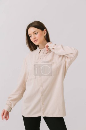 Téléchargez les photos : Photo d'une belle femme brune dans une chemise colorée isolée sur un fond blanc. Modèle de chemise. - en image libre de droit