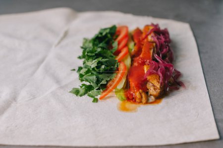 Foto de Preparación de Shawarma. Carne, verduras y salsa en pan de pita. - Imagen libre de derechos