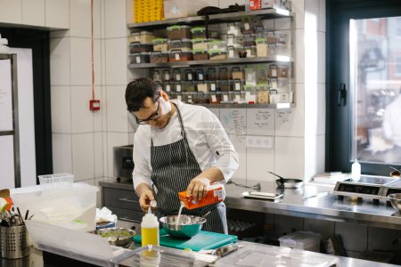 Foto de El chef prepara la comida en la cocina espaciosa y moderna. - Imagen libre de derechos