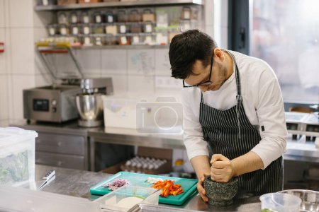Foto de Primer plano de un chef masculino preparando salsa de ajo para un restaurante - Imagen libre de derechos