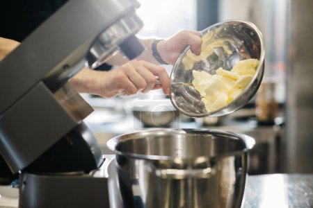 Téléchargez les photos : Faire des macarons. Un mélangeur de table de cuisine en argent pétrit la pâte pour les macarons. - en image libre de droit
