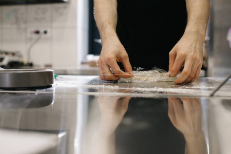 Photo for Close up. The cook wraps the dough in cling film, making macaroons or cakes. - Royalty Free Image