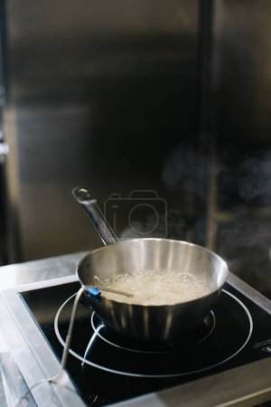 Photo for Cooking caramel in a saucepan on inductive cooking surfaces. - Royalty Free Image