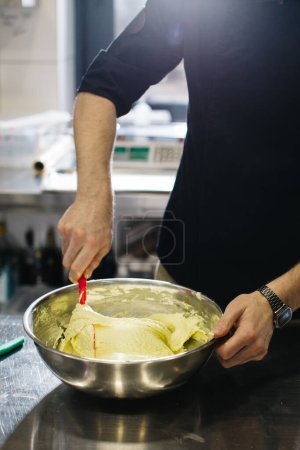 Téléchargez les photos : Le chef travaille dans la cuisine. Le processus de fabrication de la pâte pour les macarons. - en image libre de droit