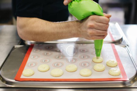 Foto de Un pastelero hace macarrones en una pastelería. - Imagen libre de derechos