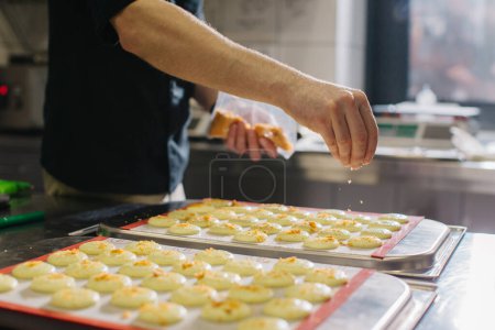 Photo for A confectioner makes macaroons in a pastry shop. - Royalty Free Image