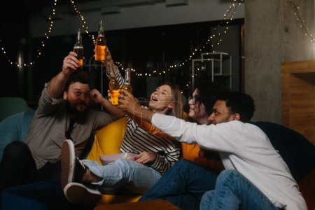 Foto de Un grupo de amigos se divierten juntos en un café por la noche, beber cerveza y charlar. - Imagen libre de derechos