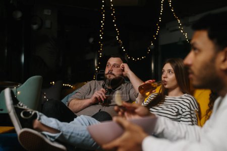 Foto de Una compañía de amigos por la noche en un café pasan tiempo juntos viendo su serie de televisión favorita. - Imagen libre de derechos