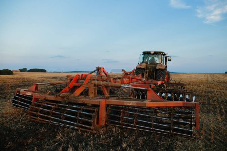 Foto de Un tractor con una grada de disco grande para labranza. Concepto de trabajo del agricultor. - Imagen libre de derechos