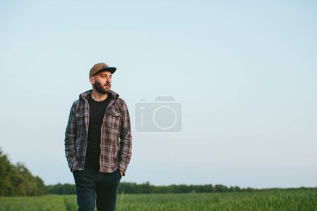 Photo for A farmer in a wheat field at sunset. An agronomist inspects a wheat field. The concept of growing a new crop. - Royalty Free Image