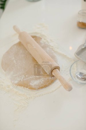 Foto de Cierre de masa de galletas y rodillo en la mesa de la cocina. - Imagen libre de derechos