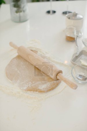Photo for Close up of cookie dough and rolling pin on kitchen table. - Royalty Free Image