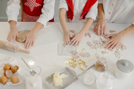 Photo for Top view, mother with children making Christmas cookies in the kitchen. - Royalty Free Image