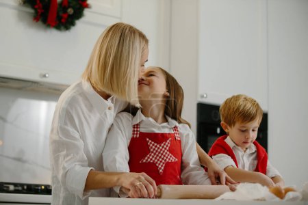 Photo for Christmas, mother and children are making cookies in the kitchen. Mother teaches children to bake cookies. - Royalty Free Image
