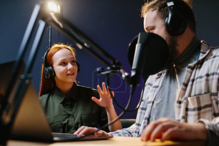 Photo for Man having conversation with woman in internet broadcast using professional microphone and audio mixer. Online radio station host recording podcast interviewing guest in late night talk show. - Royalty Free Image