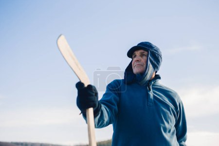Photo for Portrait of an elderly man with a hockey stick against the background of the sky. - Royalty Free Image
