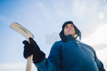 Foto de Retrato de un anciano con un palo de hockey sobre el fondo del cielo. - Imagen libre de derechos