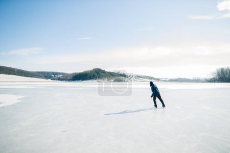Téléchargez les photos : Homme âgé en patins à glace avec bâton de hockey sur un lac gelé en hiver. Concept hobby des personnes âgées. - en image libre de droit