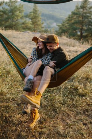 Téléchargez les photos : Un couple amoureux sont câlins tout en étant couché dans un hamac dans la nature. - en image libre de droit