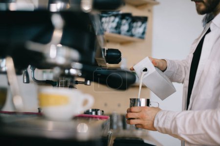 Téléchargez les photos : Barista prépare du lait pour le cappuccino. Gros plan d'un homme qui prépare un café dans un café. - en image libre de droit