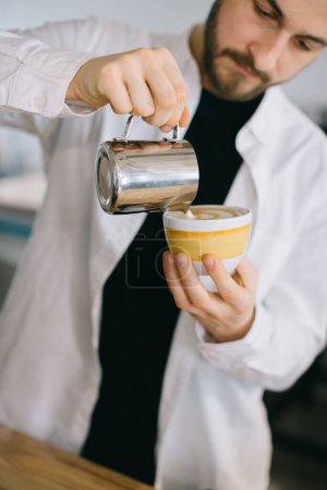 Photo for A barista near an espresso machine prepares delicious coffee. A young man prepares coffee in a cafe. - Royalty Free Image
