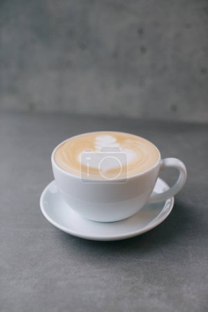 Téléchargez les photos : Gros plan d'une tasse de latte sur un fond de pierre grise. - en image libre de droit