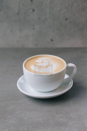 Foto de Primer plano de una taza de café con leche sobre un fondo de piedra gris. - Imagen libre de derechos