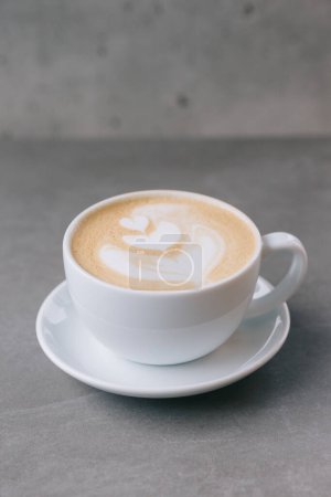 Téléchargez les photos : Gros plan d'une tasse de latte sur un fond de pierre grise. - en image libre de droit