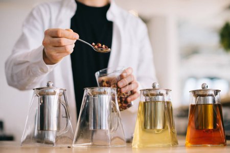 Téléchargez les photos : Un jeune barista prépare de délicieux thés dans un café moderne. - en image libre de droit