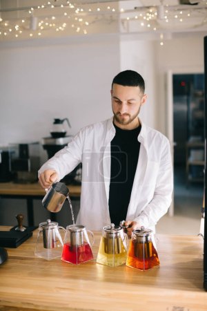 Téléchargez les photos : Un jeune barista prépare de délicieux thés dans un café moderne. - en image libre de droit