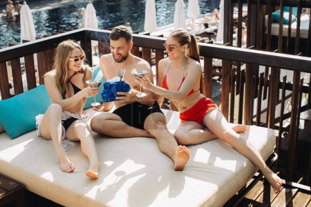 Téléchargez les photos : Un groupe d'amis joyeux se relaxe au bord de la piscine. - en image libre de droit