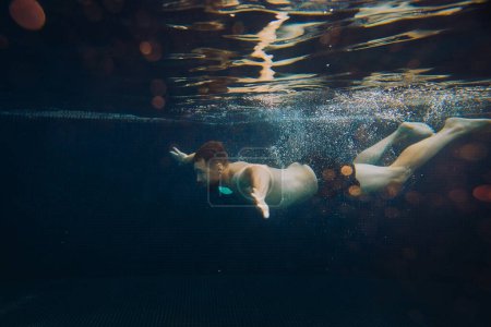 Foto de Un joven nada bajo el agua en una piscina. Concepto vacaciones de verano. - Imagen libre de derechos