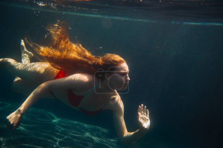 Téléchargez les photos : Jeune femme rousse nageant sous l'eau dans un caca - en image libre de droit
