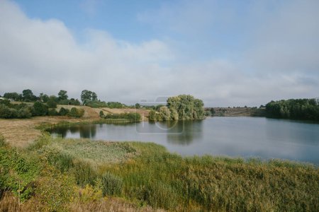Téléchargez les photos : Un paysage pittoresque avec un étang près du village. - en image libre de droit