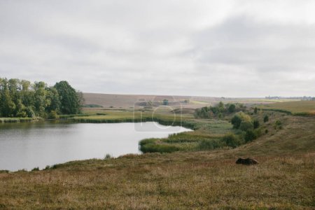 Téléchargez les photos : Un paysage pittoresque avec un étang près du village. - en image libre de droit