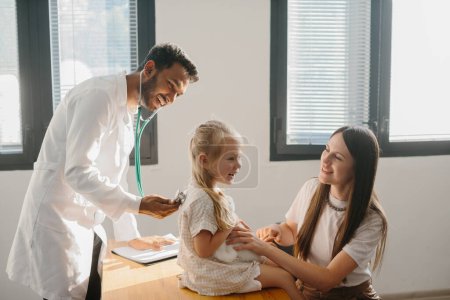 Photo for Male Pediatrician examining cute little girl with stethoscope - Royalty Free Image