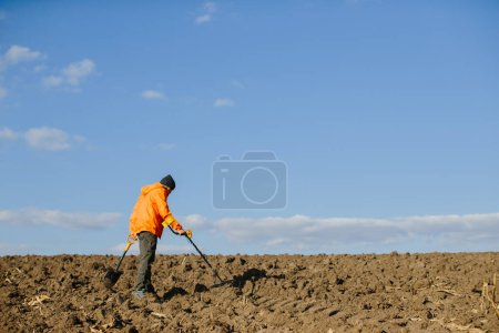 Téléchargez les photos : Un homme avec un détecteur de métaux sur le terrain. Recherche de trésors. - en image libre de droit