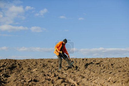 Photo for Man with a metal detector in the field. Search for treasures. - Royalty Free Image