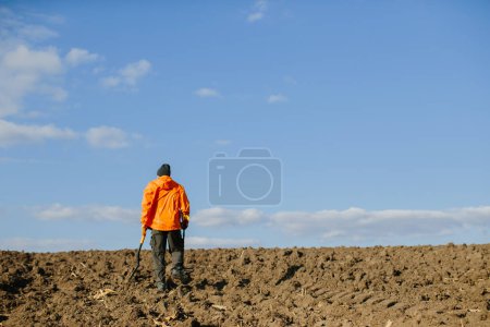 Photo for Man with a metal detector in the field. Search for treasures. - Royalty Free Image