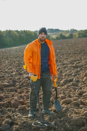 Téléchargez les photos : Un homme aime l'archéologie récréative avec un détecteur de métaux dans un champ - en image libre de droit