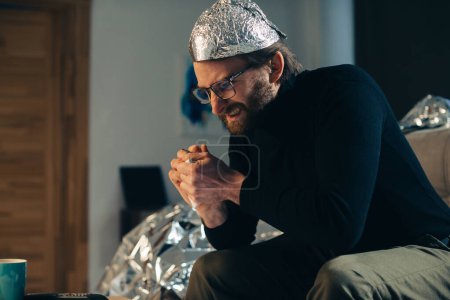 Foto de Una búsqueda paranoica: un hombre arruga sábanas en busca de una conspiración global. - Imagen libre de derechos