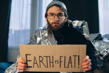 Avocat de la Terre Plat : L'homme en Tin Foil Chapeau et couvertures tient signe 'La Terre est Plate
