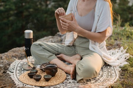 Foto de Ceremonia de té en las montañas al atardecer. Una joven medita en la naturaleza. - Imagen libre de derechos