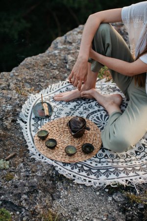 Foto de Una joven hermosa mujer realiza una ceremonia de té chino en las montañas al atardecer. - Imagen libre de derechos