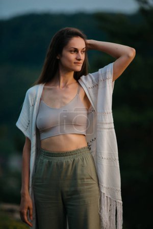 Photo for Portrait of a beautiful young brunette woman in the rays of the evening sun in the mountains. - Royalty Free Image