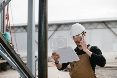 Foto de Un ingeniero inspecciona la construcción de silos de almacenamiento de granos. - Imagen libre de derechos