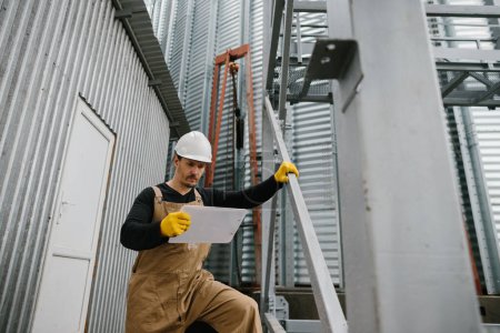 Foto de Un ingeniero inspecciona la construcción de silos de almacenamiento de granos. - Imagen libre de derechos