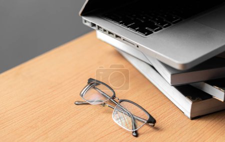 Foto de Creatividad creativa Escritorio de diseño web con libros, laptop y gafas sobre fondo de madera - Imagen libre de derechos