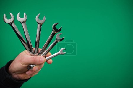 Metal double-sided open-end wrench with chrome-plated tool for connecting and disconnecting threaded connections. advertising Green background chromakey free space